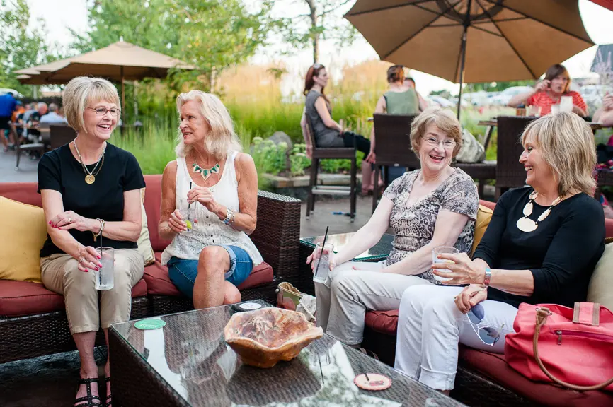 Four Middle age women dining out on a patio at Porter Creek Hardwood Grill